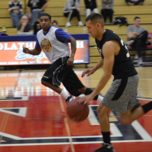 Two men playing basketball, racing down the court